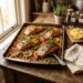 Roasted salmon fillets and golden chickpeas on a rustic baking tray with fresh parsley and lemon, photographed in natural window light on an aged wooden surface